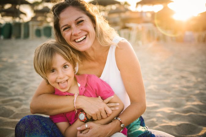 Happy mother with playful son on beach