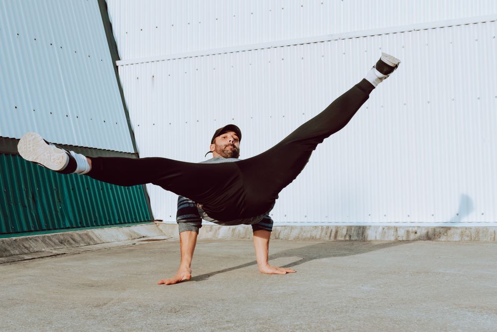 Man performing handstand near wall