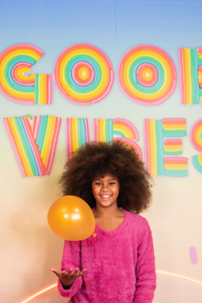 Cheerful Black girl with air balloons in studio