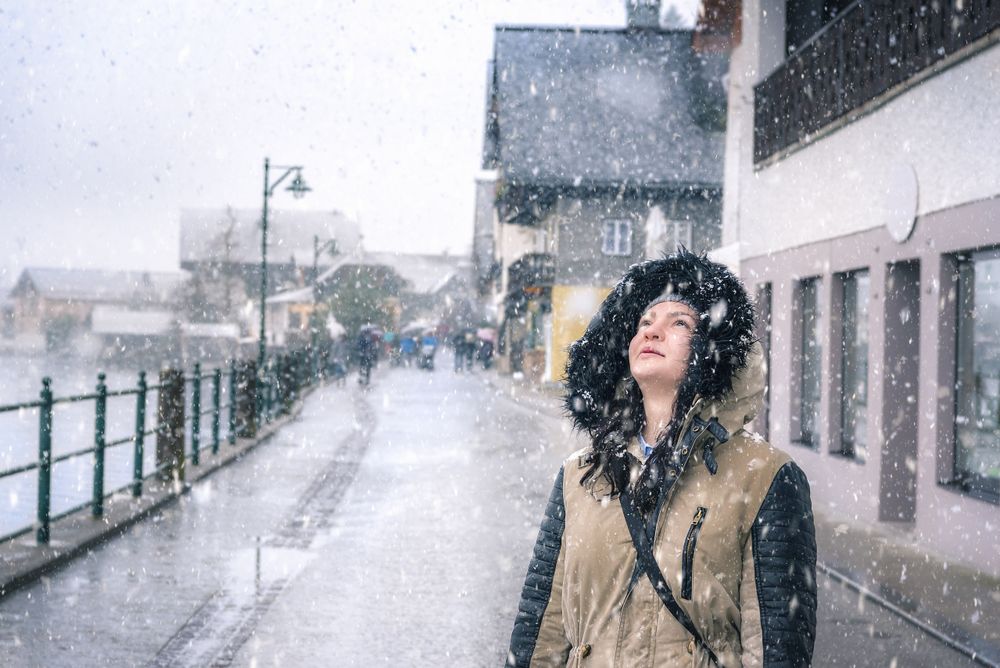 Happy woman looking up at snowflakes