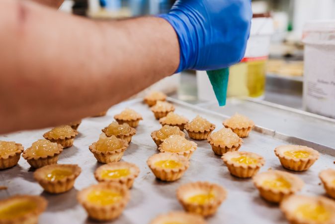 Crop baker squeezing dough on tray