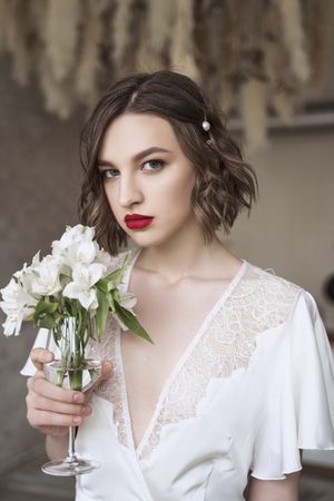 woman with red lips holding white flowers and dreaming