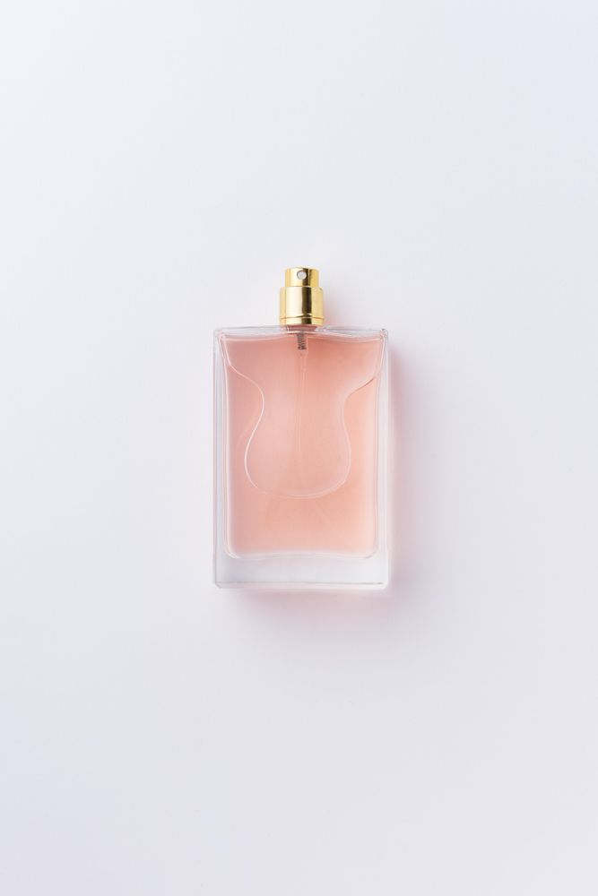 Pink perfume over pale background