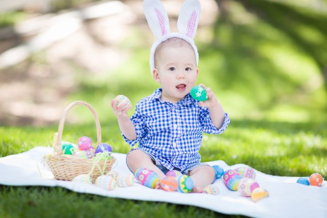 Biracial Baby Boy Outside In Ears Playing with Easter Eggs