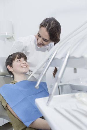 Dentist about to examine little boy's teeth in chair