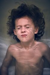 Funny little boy diving in bathtub at home
