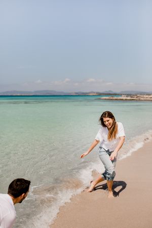 Cheerful lovers having fun on tropical coastline