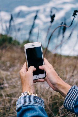 Person using smartphone while chilling at coast