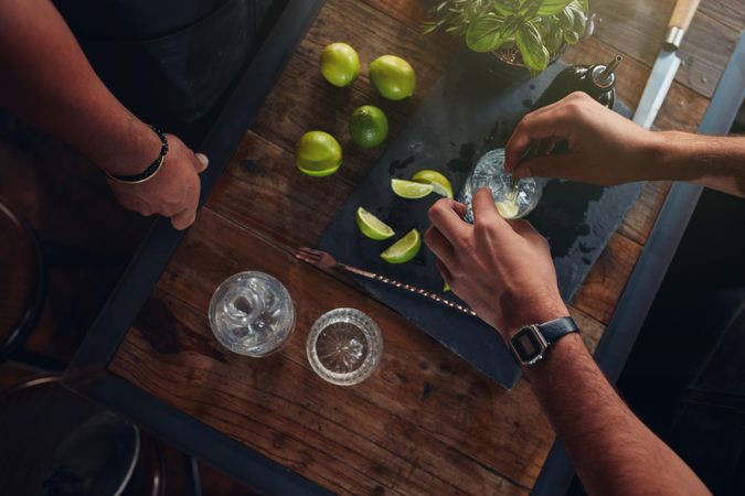 Hands of barmen with ingredients on the wooden counter