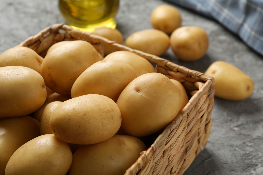 Wicker box of potatoes on marble table