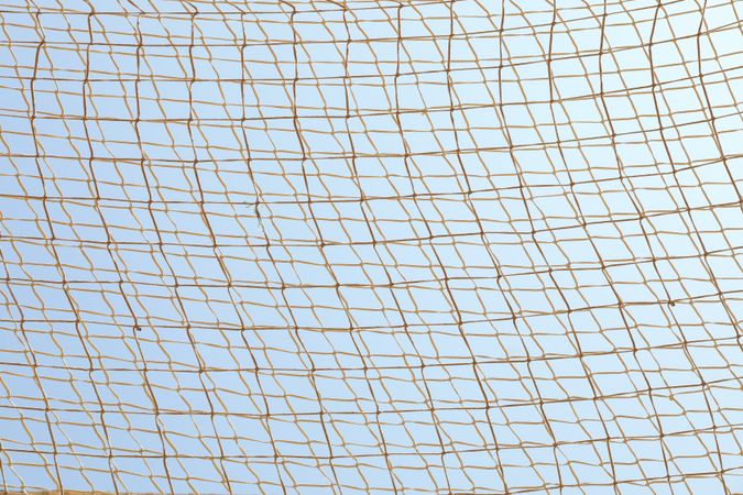Football net against blue sky background, space for text