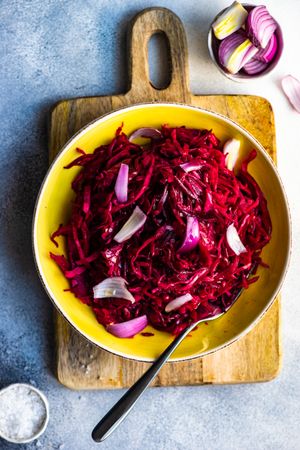 Top view of cabbage and beetroot salad yellow bowl on counter