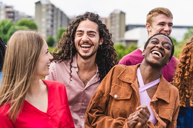 Multiethnic cheerful community of young friends gathering outdoors