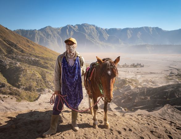 Java Island, Indonesia - August, 14 2015: Person with horse in volcanic region