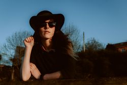 Dreaming stylish woman in sunglasses and hat