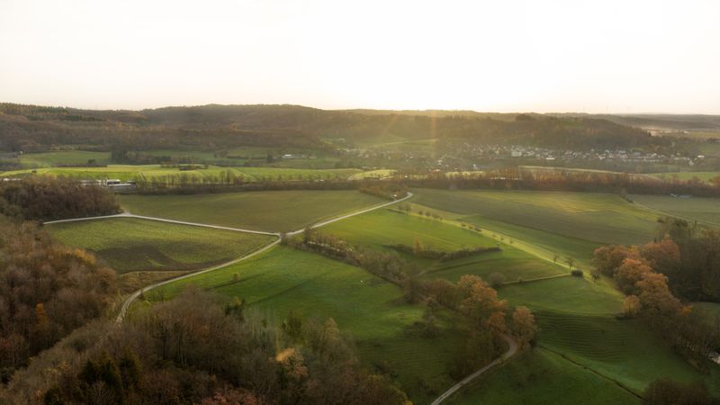 Aerial view with agricultural fields at sunrise on a sunny autumn day