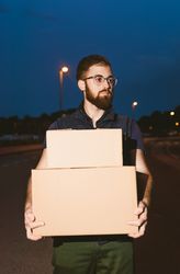 Courier delivering cardboard boxes in evening