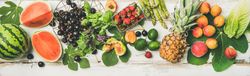 Summer fruits of watermelon halves, cherries, figs, strawberry on wood