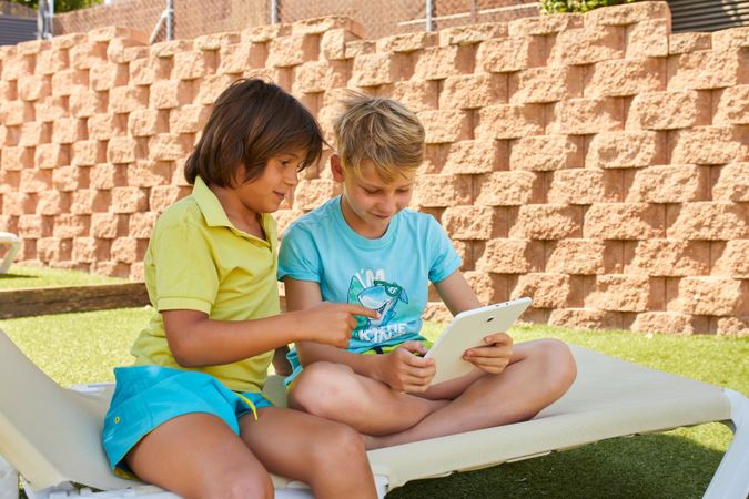 Boys using tablet in garden