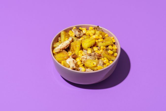 Tropical salad bowl, roasted  and isolated on a purple background