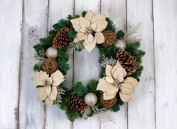 Holiday Poinsettia Christmas wreath on rustic wooden boards