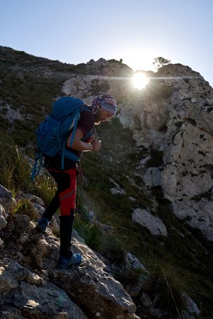 Male hiker with backpack standing on cliff