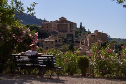 Man relaxing on bench against ancient town
