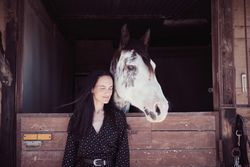Woman near horse in stall