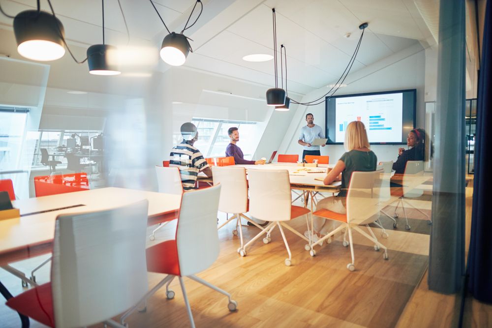 Group of people discussing a chart at a meeting in an open modern office