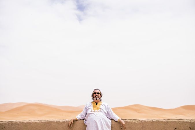 Cheerful adult man in desert