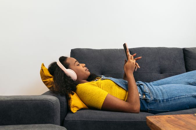 Young woman enjoys music and phone