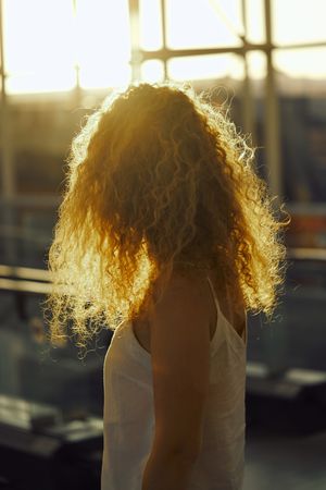 Smiling woman walking in spacious hall in sunlight