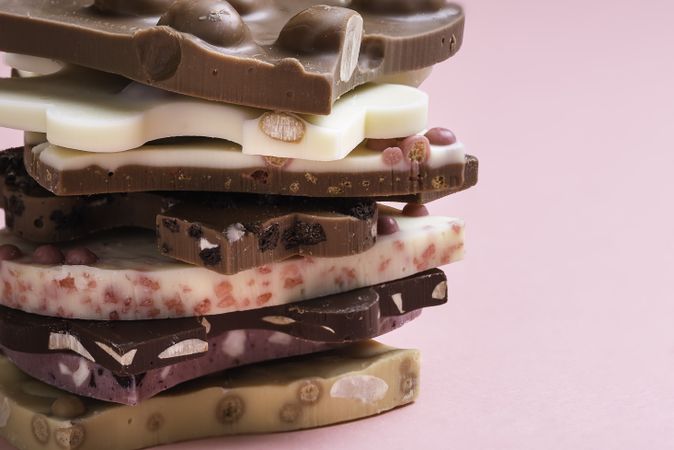 Swiss chocolate assortment in a stack on pink background