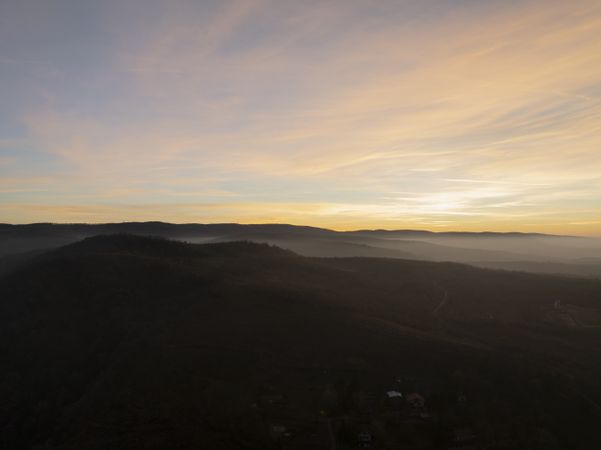 Golden Horizon Over Misty Hills and Scattered Homes.