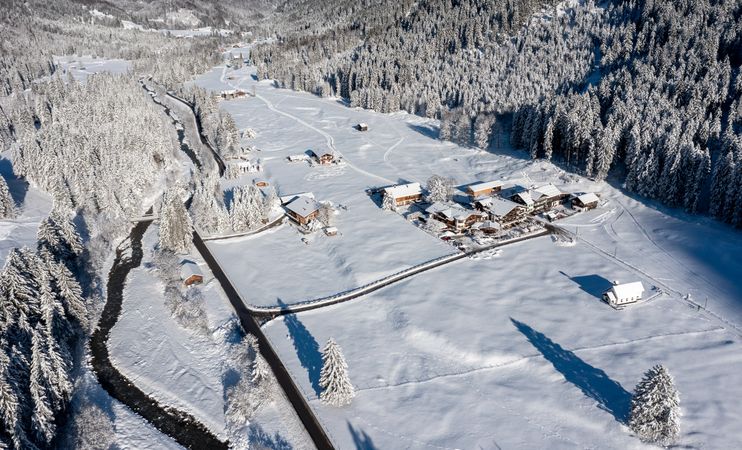 Aerial view on a sunny day in winter with snow-covered nature in the Bavarian Alps, Germany
