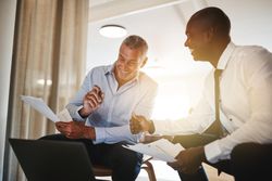 Two men smiling together while working together