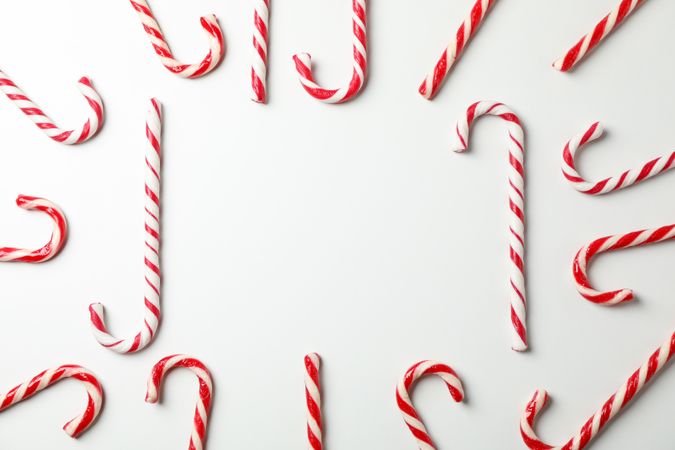 Composition with sweet candy canes on plain background, space for text