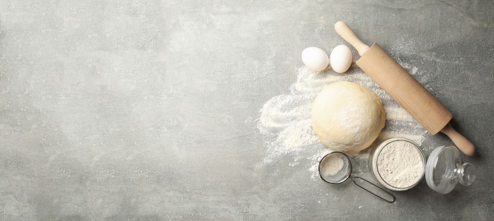 Concept for baking with dough on gray background