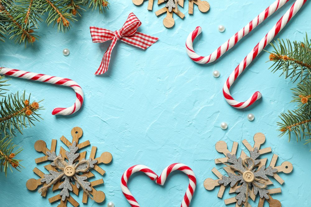 Candy canes and christmas accessories on blue background, space for text