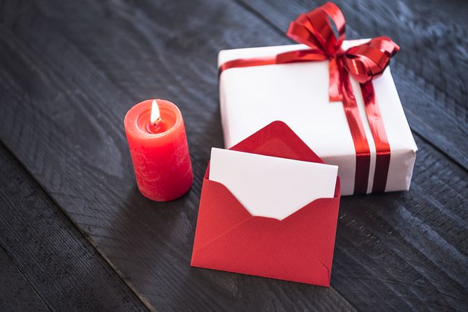 Present ties with ribbon on a table next to a lit candle