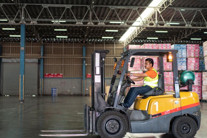 Man driving forklift in factory