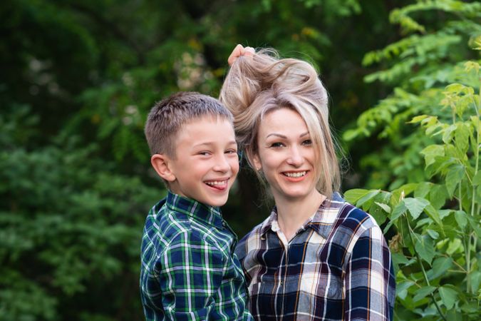 Son playing with mother's hair in backyard