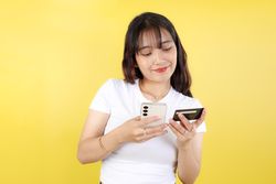 Portrait of Happy Indonesian Woman Using Credit Card and Smartphone App