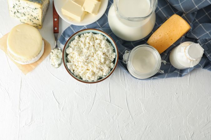 Flat lay. Different dairy products on bright background, copy space