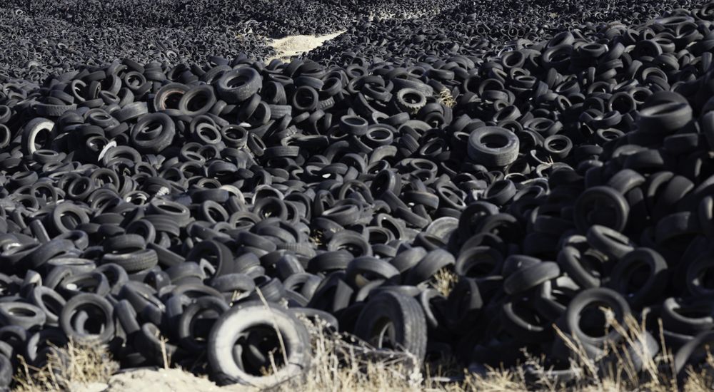 Heap of old tires between field