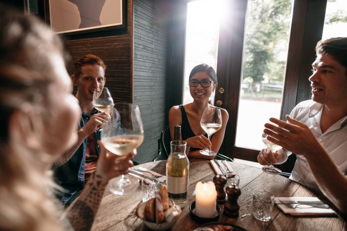 Group of men and women enjoying a glass of wine at restaurant