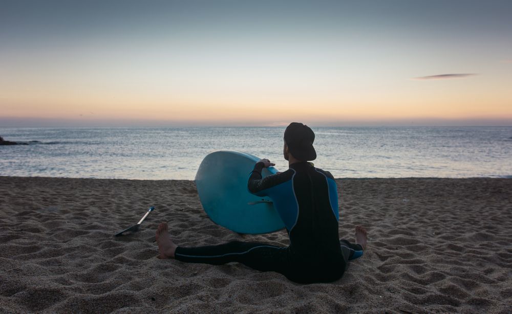 Man practicing paddle surfing with neoprene in a sunrise