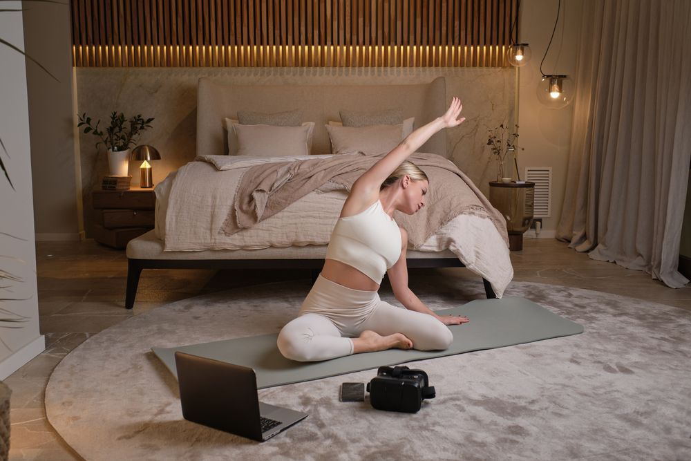 Woman doing yoga and stretching in bedroom at home