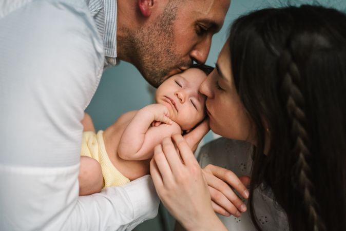 Parents holding baby in room
