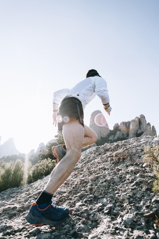 Man running up rocky trail